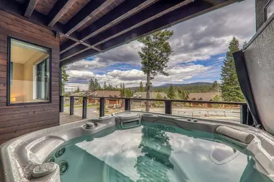 a hot tub in a house with a large window at Village Walk 7470 by East West Hospitality in Truckee