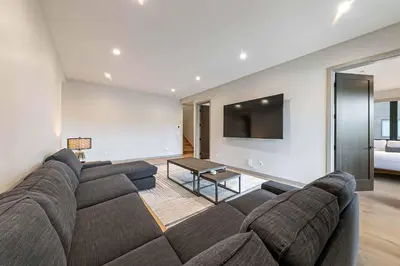 a living room with a large couch and a table at Village Walk 7470 by East West Hospitality in Truckee