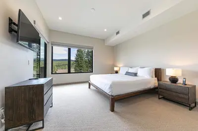 a bedroom with a bed and a large window at Village Walk 7470 by East West Hospitality in Truckee