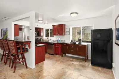 a kitchen with wooden cabinets and a black refrigerator at Rivertop Hideaway in Ahwahnee