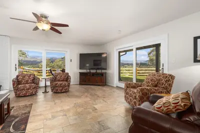 a living room with a couch and chairs and a flat screen tv at Rivertop Hideaway in Ahwahnee