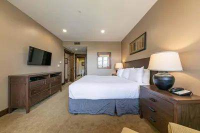 a bedroom with a large bed and a television at Northstar Lodge 306 by East West Hospitality in Truckee