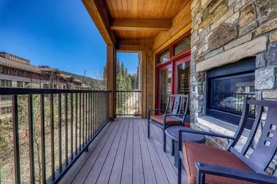 a deck with chairs and a fireplace on a house at Northstar Lodge 306 by East West Hospitality in Truckee