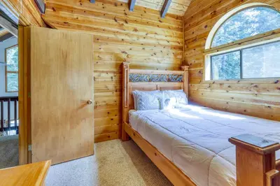 a bedroom with a bed in a log cabin at Resting Bear Lodge by Tahoe Getaways - Pet Friendly w Foosball and HOA Amenities in Truckee