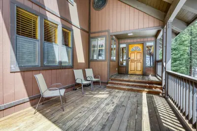 a porch of a house with two chairs and a door at Resting Bear Lodge by Tahoe Getaways - Pet Friendly w Foosball and HOA Amenities in Truckee