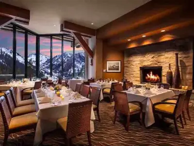 a dining room with tables and chairs and a fireplace at Everline Resort & Spa Palisades- Forest View in Olympic Valley