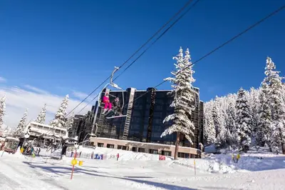a person is on a ski lift in the snow at Everline Resort & Spa Palisades-Valley View Suite in Olympic Valley