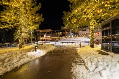 a street covered in snow at night with christmas lights at Everline Resort & Spa Palisades-Valley View Suite in Olympic Valley
