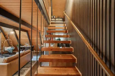 a staircase in a house with wooden walls at Sequoia A-frame Nirvana: Modern + Views + Hot Tub in Ponderosa