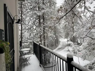 a balcony with snow covered trees and a table and chairs at Enjoy the outdoors 1st Apple hill exit Tahoe in Placerville