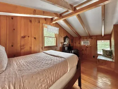 a bedroom with a bed in a room with wooden walls at Homestead Ranch near Yosemite with Horses and Chickens in Midpines