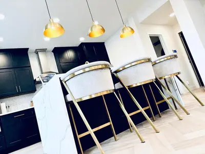 a row of chairs in a kitchen with black cabinets at Experience Serenity Luxe 4BDR Lake House 25ft Pool in Elk Grove