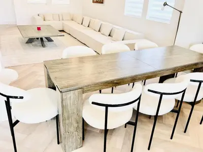 a dining room with a wooden table and white chairs at Experience Serenity Luxe 4BDR Lake House 25ft Pool in Elk Grove