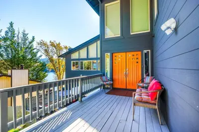 a porch of a house with a orange door at Massive 8 bedroom on the lake in Groveland