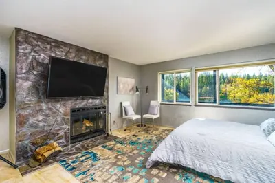 a bedroom with a fireplace and a flat screen tv at Massive 8 bedroom on the lake in Groveland