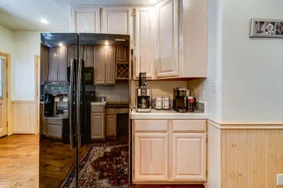 a kitchen with wooden cabinets and a black refrigerator at Truckee Retreat half Mi to Tahoe Donner Skiing in Truckee
