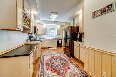a kitchen with wooden cabinets and a rug on the floor at Truckee Retreat half Mi to Tahoe Donner Skiing in Truckee