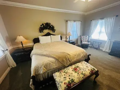 a bedroom with a large bed and two windows at Pinkie's Suite -Hot Tub-BBQ-views in Ahwahnee