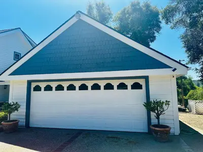 a white garage door with a green roof at Pinkie's Suite -Hot Tub-BBQ-views in Ahwahnee