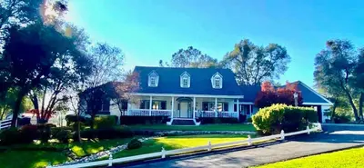 a large blue house with a white fence at Pinkie's Suite -Hot Tub-BBQ-views in Ahwahnee