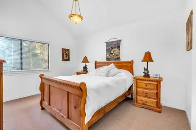 a bedroom with a wooden bed and two night stands at Fully Renovated 3Bd at Yosemite's South Gate in Fish Camp