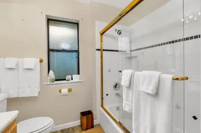 a white bathroom with a shower and a toilet at Fully Renovated 3Bd at Yosemite's South Gate in Fish Camp