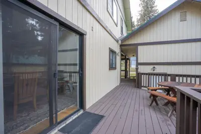 an outdoor deck with a table and a bench at Fully Renovated 3Bd at Yosemite's South Gate in Fish Camp