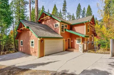 a house with a garage in the woods at Beautiful 3bd Sanctuary Inside Yosemite in Wawona