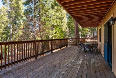 a wooden deck with a table and chairs on it at Yosemite Quail - Nestled in with a View in Yosemite West