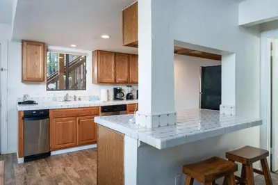 a kitchen with wooden cabinets and a counter top at Yosemite Quail - Nestled in with a View in Yosemite West