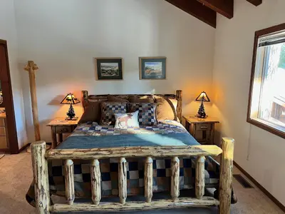 a bedroom with a wooden bed with two lamps on tables at Serene Vistas at Northstar in Truckee