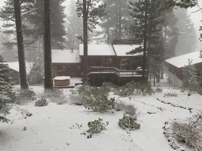 a house covered in snow in front of a house at Serene Vistas at Northstar in Truckee