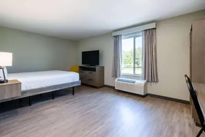 a bedroom with a bed and a tv and a window at ECHO Suites Extended Stay by Wyndham Reno in Reno