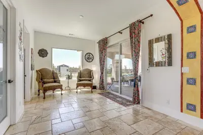 an arched hallway with two chairs and a window at 8 Mi to Lodi Lake Luxe Home with On-Site Vineyard in Acampo