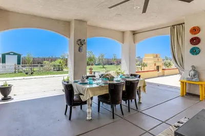 a dining room with a table and chairs and windows at 8 Mi to Lodi Lake Luxe Home with On-Site Vineyard in Acampo