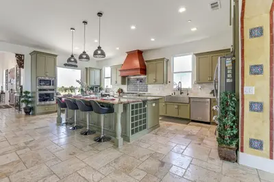 an open kitchen with a large island with bar stools at 8 Mi to Lodi Lake Luxe Home with On-Site Vineyard in Acampo