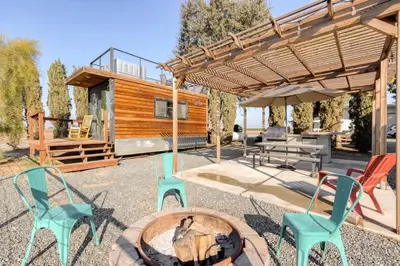 a backyard with a fire pit and chairs and a cabin at Rooftop Spa Tiny Cargo Home Farm Experience in Tulare