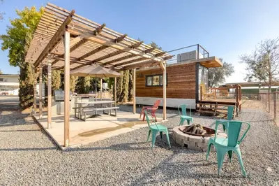 a pavilion with chairs and a fire pit in front of a house at Rooftop Spa Tiny Cargo Home Farm Experience in Tulare
