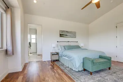 a white bedroom with a bed and a chair at On-Site Vineyard Gem on 10 Acres in Pilot Hill! in Pilot Hill