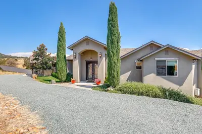 a house with trees in front of a driveway at On-Site Vineyard Gem on 10 Acres in Pilot Hill! in Pilot Hill