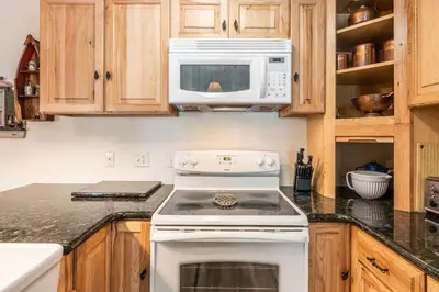 a kitchen with a white stove and a microwave at Sunshine Village 120 in Mammoth Lakes