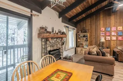 a living room with a table and a fireplace at Sunshine Village 120 in Mammoth Lakes