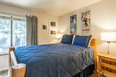 a bedroom with a blue bed and a window at Sunshine Village 120 in Mammoth Lakes