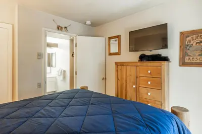 a bedroom with a bed and a tv and a dresser at Sunshine Village 120 in Mammoth Lakes