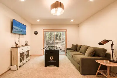 a living room with a couch and a table at Jackpine Lodge at Tahoe Donner by Tahoe Getaways - Private Hot Tub w Foosball and HOA in Truckee