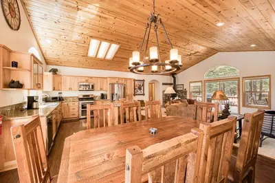 a kitchen with a large wooden table and chairs at Jackpine Lodge at Tahoe Donner by Tahoe Getaways - Private Hot Tub w Foosball and HOA in Truckee