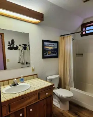 a bathroom with a sink and a toilet and a mirror at Relax Inn - Close to Attractions Galore in Truckee