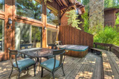 a patio with a table and chairs on a deck at Ridge Court Barrel - Relax in Private Hot Tub in Olympic Valley