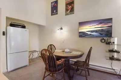 a kitchen with a table and a white refrigerator at Regency Retreat - Studio for 2 in Tahoe Vista