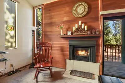 a fireplace in a living room with a clock on the wall at Regency Retreat - Studio for 2 in Tahoe Vista